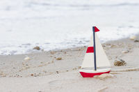 Spielzeug-Segelschiff am Strand
